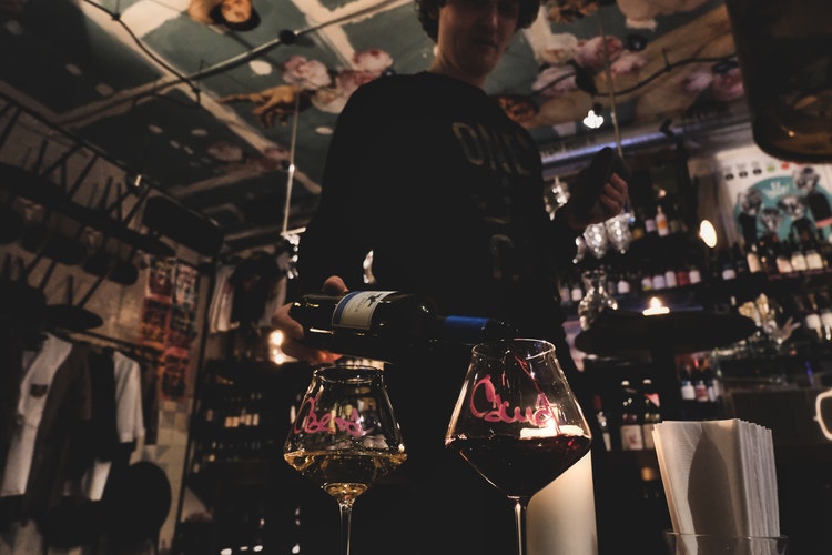 Server carrying a flight of wine glasses in a wine bar